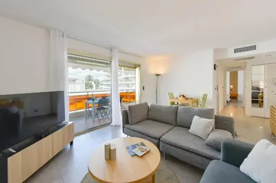 a living room with a couch and a tv and a table at Renovated 1Br apartment terrace walk to beach in Cannes