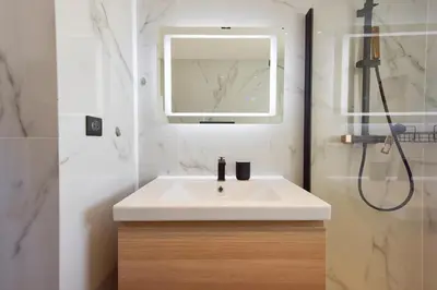 a bathroom with a white sink and a shower at Renovated 1Br apartment terrace walk to beach in Cannes