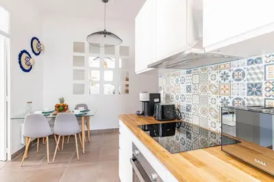 a kitchen with white cabinets and a table with chairs at Le Louis- Superbe logement à 5mins des plages, proche Palais in Cannes