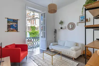 a living room with a couch and a red chair at Le Louis- Superbe logement à 5mins des plages, proche Palais in Cannes