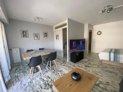a room with a bed and a desk and chairs at Cannes centre Lou Souquetan in Cannes