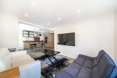a living room with a couch and a tv on a wall at Centre ville Croisette in Cannes