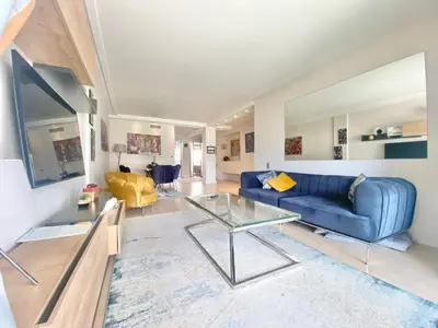 a living room with a blue couch and a glass table at Grand Hotel 2 chambres 2 sdb - GH in Cannes
