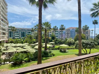 a balcony of a resort with tables and umbrellas at Grand Hotel 2 chambres 2 sdb - GH in Cannes