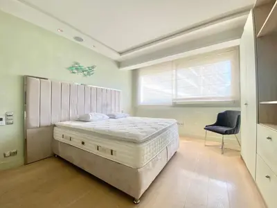 a bedroom with a large bed and a chair at Grand Hotel 2 chambres 2 sdb - GH in Cannes