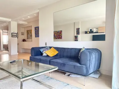 a blue couch in a living room with a glass table at Grand Hotel 2 chambres 2 sdb - GH in Cannes