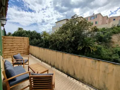 a patio with chairs and tables and a fence at Grand studio avec terrasse in Cannes