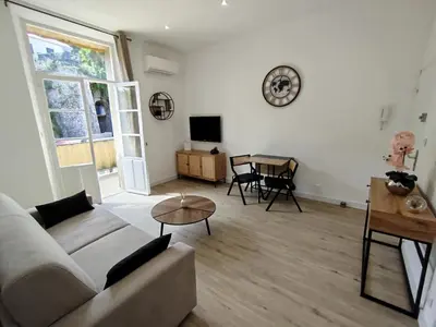 a living room with a couch and a table at Grand studio avec terrasse in Cannes
