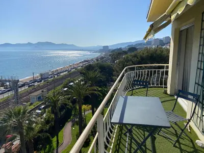 a balcony with a table and a view of the ocean at Appartement vue panoramique sur Cannes, 100M2 3P in Cannes