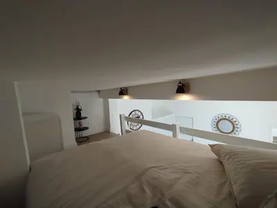 a bedroom with a bed and a white wall at Studio mezzanine in Cannes