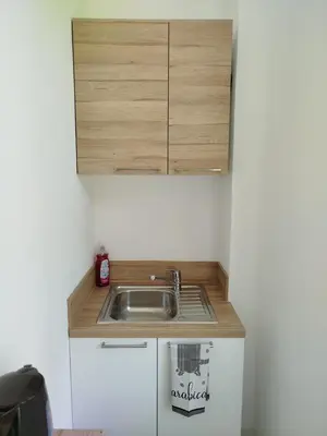 a kitchen with a sink and a wooden cabinet at Studio mezzanine in Cannes
