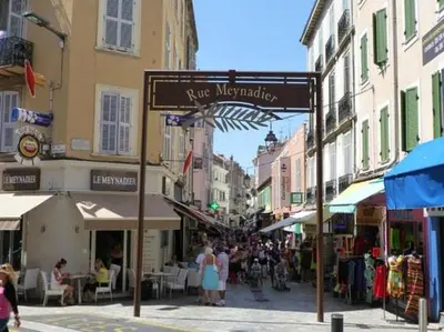 a street sign in a city with people walking down a street at Studio mezzanine in Cannes