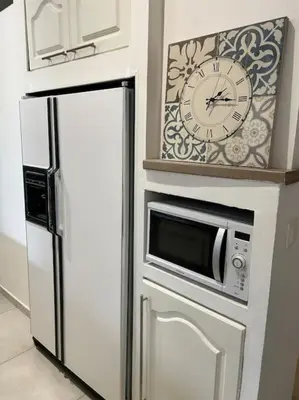 a white refrigerator with a clock on top of it at Résidence Cannes Plage Business Saisonnier in Cannes