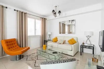 a living room with a white couch and an orange chair at Cosy 2-Bedroom apartment - close to Martinez Hotel in Cannes