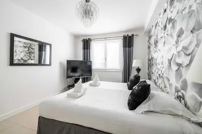 a bedroom with a large white bed with a television at Cosy 2-Bedroom apartment - close to Martinez Hotel in Cannes