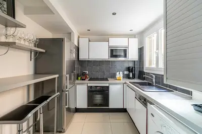 a kitchen with white cabinets and white appliances at Cosy 2-Bedroom apartment - close to Martinez Hotel in Cannes