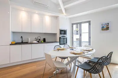 a kitchen and dining room with a white table and chairs at Charming apartment - Near the Old Port and Suquet in Cannes