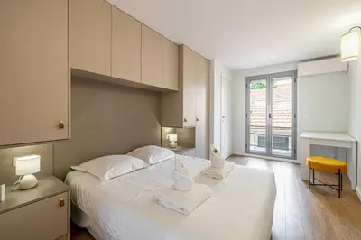 a bedroom with a large white bed with towels on it at Charming apartment - Near the Old Port and Suquet in Cannes