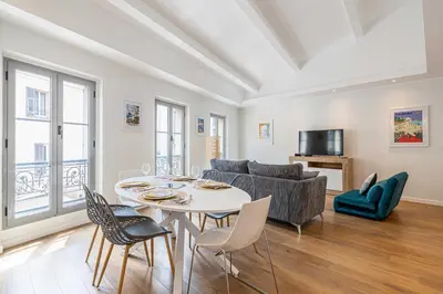 a living room with a table and chairs and a couch at Charming apartment - Near the Old Port and Suquet in Cannes