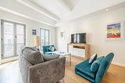 a living room with a couch and a tv at Charming apartment - Near the Old Port and Suquet in Cannes