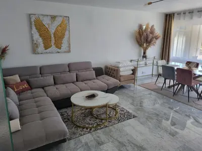 a living room with a couch and a table at Spacieux 2 pièces terrasse et piscine in Cannes