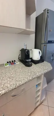 a kitchen counter with a toaster and a refrigerator at Spacieux 2 pièces terrasse et piscine in Cannes