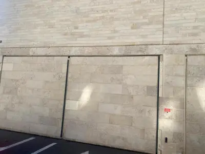 a large brick wall with a door on it at Spacieux 2 pièces terrasse et piscine in Cannes