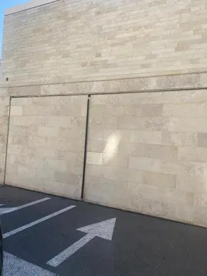 a brick wall with a white arrow on a parking lot at Spacieux 2 pièces terrasse et piscine in Cannes