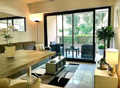 a living room with a couch and a table at Appartement 3 Etoiles centre moderne terrasse piscine parking in Cannes