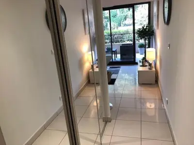 a view of a living room with a mirror at Appartement 3 Etoiles centre moderne terrasse piscine parking in Cannes