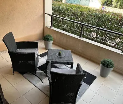 a patio with chairs and a table and a balcony at Appartement 3 Etoiles centre moderne terrasse piscine parking in Cannes