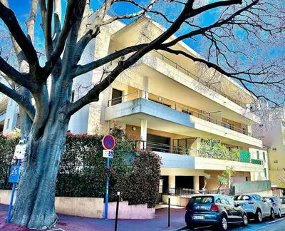 a large building with cars parked in front of it at Appartement 3 Etoiles centre moderne terrasse piscine parking in Cannes