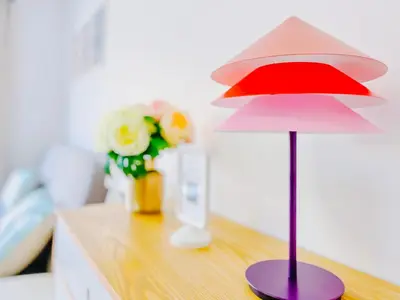 a red and white lamp on a desk with flowers at Le Cannes Mélodie - Terrasse in Cannes