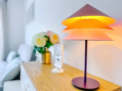 a lamp on a table with a vase of flowers at Le Cannes Mélodie - Terrasse in Cannes