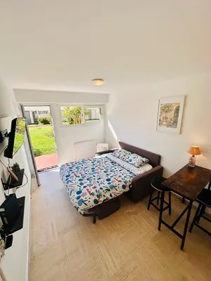 a small bedroom with a bed and a table at Charmant Studio à 5 minutes des plages in Cannes