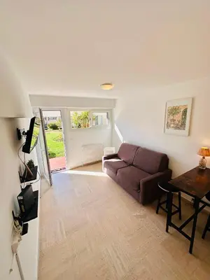 a living room with a couch and a table at Charmant Studio à 5 minutes des plages in Cannes