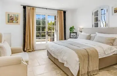 a bedroom with a large bed and a window at La Pastourelle in Le Cannet