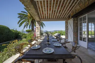 a long wooden table with chairs on a patio at La Pastourelle in Le Cannet