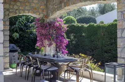 a table with chairs and a vase of purple flowers at La Pastourelle in Le Cannet