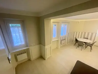 an empty room with a table and chairs and windows at La Brise by Connexion in Cannes