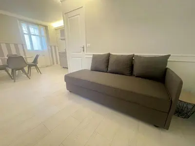 a couch in a living room with a table and chairs at La Brise by Connexion in Cannes
