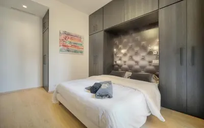 a bedroom with a large bed with a large headboard at TOP renovated 1 bedroom near Palais 2P1 by RIVAEVENT in Cannes