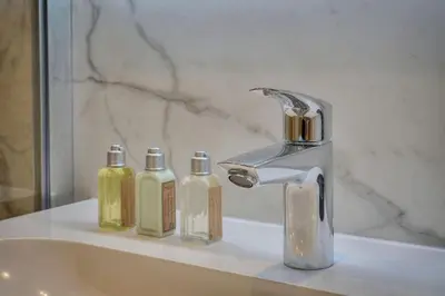 a bathroom sink with a faucet and two soap bottles at TOP renovated 1 bedroom near Palais 2P1 by RIVAEVENT in Cannes