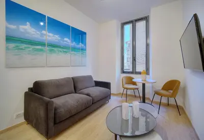 a living room with a couch and a table at TOP renovated 1 bedroom near Palais 2P1 by RIVAEVENT in Cannes