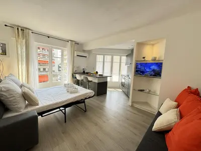 a living room with a couch and a kitchen at Studio confortable proche mer deb1890 in Cannes