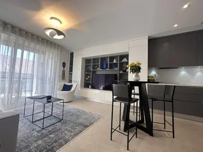 a kitchen with black cabinets and a table and chairs at Appartement centre ville 7 Lecerf in Cannes