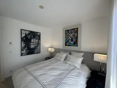 a bedroom with a white bed with two pictures on the wall at Appartement centre ville 7 Lecerf in Cannes