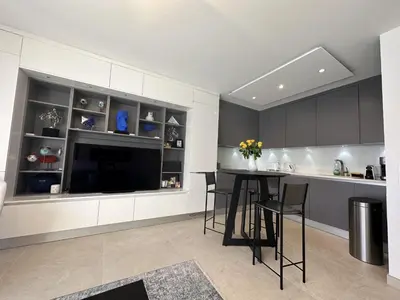 a kitchen with a table with chairs and a tv at Appartement centre ville 7 Lecerf in Cannes