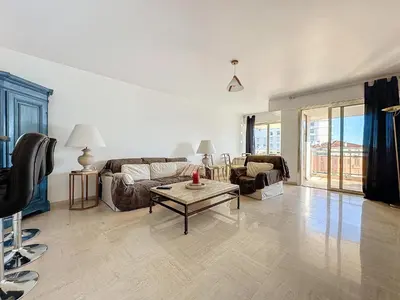 a living room with a couch and a table at 78m2 Terrasse vue mer à 50m de la Croisette in Cannes