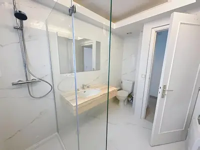 a bathroom with a glass shower and a sink at 78m2 Terrasse vue mer à 50m de la Croisette in Cannes